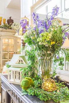 a vase filled with purple flowers sitting on top of a table