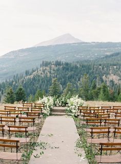 an outdoor ceremony set up with wooden chairs and flowers