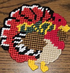 a close up of a cross stitch turkey on a table