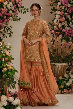 a woman in an orange lehenga with gold sequins