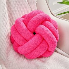 a pink knot sitting on top of a white couch