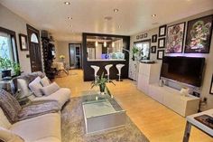 a living room filled with furniture and a flat screen tv on top of a wooden floor