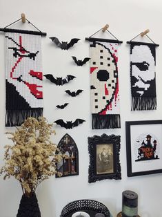 halloween decorations are hung on the wall in front of a vase with flowers and candles