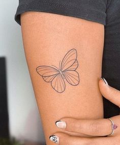 a woman's arm with a butterfly tattoo on the left side of her body