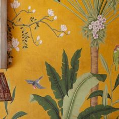 a yellow wall with flowers and birds painted on it