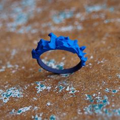 a blue ring sitting on top of a brown table covered in dirt and sprinkles