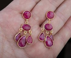 An exquisite piece of art work, this pair of three-tier genuine ruby earrings would be nice reward for yourself or a great gift for your mother or best friend.Each one has three layers of natural ruby stones set in leaflet shaped, gold plated bezels and laid in a dangling willow branch pattern.1. Stones : ruby (natural gemstone)2. Stone shape and size:     top tier: a bezeled round ruby 10mm    middle tier: a bezeled oval ruby 14 x 10 mm    bottom tier: three dangling pear shaped ruby 14 x 11 mm Handmade Ruby Dangle Earrings, Elegant Ruby Chandelier Dangle Earrings, Ruby Drop Chandelier Earrings As Gift, Elegant Ruby Chandelier Earrings For Gift, Ruby Gemstone Dangle Jewelry, Gold Ruby Chandelier Earrings As Gift, Ruby Dangle Earrings As Gift, Handmade Ruby Earrings For Anniversary, Ruby Earring