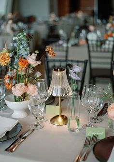 the table is set with flowers and silverware