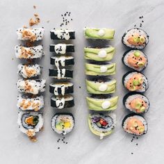 an assortment of sushi on a white surface