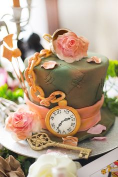 there is a cake with flowers on it and an old clock in the middle that has been decorated