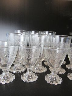 a group of wine glasses sitting next to each other on a black counter top in front of a mirror