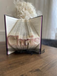 an open book sitting on top of a wooden table