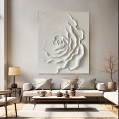 a living room filled with furniture and a large white painting on the wall above it