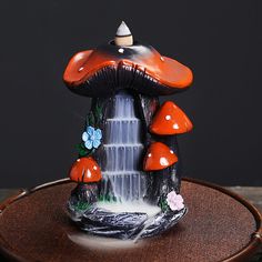 an orange and black mushroom statue sitting on top of a wooden table