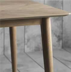 a wooden table sitting on top of a tile floor next to a white tiled wall