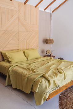 a large bed sitting in a bedroom next to a wall with wood paneling on it