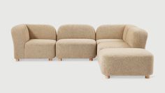 a beige couch and ottoman sitting next to each other