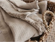 a basket filled with blankets sitting on top of a floor next to a blanket and pillow