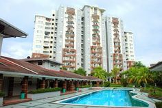 an apartment complex with a swimming pool in the foreground