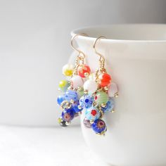 Millefiori dangle earrings are so cute and colorful! Packed with small (4 mm) multicolor millefiori glass beads, the earrings are perfect for summer and add color to any outfit. Gold-plated.  Height: 1.9 inches / 4,8 cm, including the earwire. Looking for a set? Here's a matching... necklace: https://www.etsy.com/listing/1270181471 ring: https://www.etsy.com/listing/1118874356 bracelet: https://www.etsy.com/listing/1256169342 ♥ Jewelry care ♥ It's important to keep your jewelry dry: Take it off Multicolor Glass Drop Earrings, Elegant Multicolor Round Beads Flower Earrings, Multicolor Flower-shaped Earrings With Dangling Beads, Elegant Multicolor Czech Glass Beaded Earrings, Multicolor Glass Beaded Earrings, Multicolor Glass Earrings With Colorful Beads, Multicolor Glass Bohemian Earrings, Multicolor Bohemian Glass Earrings, Bohemian Multicolor Glass Earrings