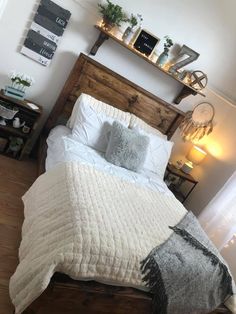 a bed with white sheets and pillows in a room