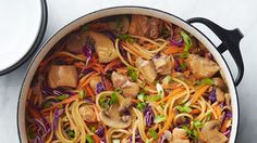 a pot filled with noodles and vegetables on top of a table