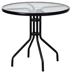 a round glass table with black metal legs and an iron base, against a white background