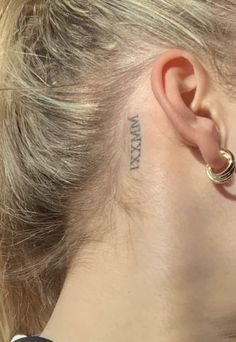 a woman with a small tattoo behind her ear