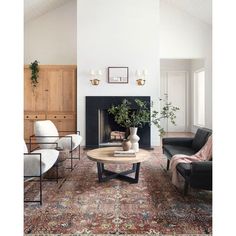 a living room filled with furniture and a fire place in the middle of a room