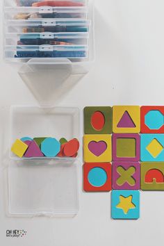 several different shapes and sizes of magnets in plastic containers on top of a white surface