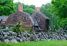 an old wooden house surrounded by rocks and trees