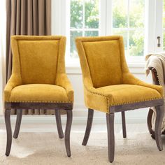 two yellow chairs sitting next to each other in front of a window