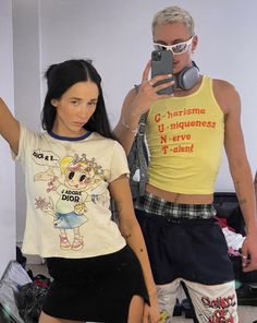 a man taking a selfie with a woman in front of him wearing shorts and a t - shirt