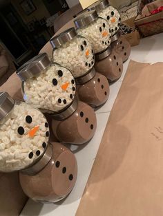 snowmen made out of popcorn are sitting on the counter next to some brown paper