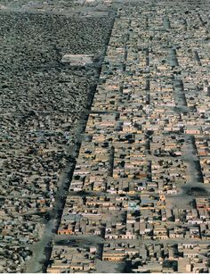 an aerial view of a large city with lots of houses and buildings in the distance