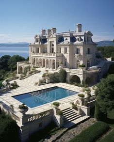 an aerial view of a large mansion with a pool in the foreground and stairs leading up to it