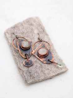 Inspiration for this pair of handmade earrings was this summers june full moon, which brought a lot of joy and i guess they are filled with that emotion. the earrings have a dynamic shape and the titanium agate sparkling dots on the oxidized copper surface are eye-catching. what's interesting and unique about these earrings is that they have the same shape, but the ornamentation is asymmetrical, which makes them even more interesting for avant-garde girls and women who like raw, minimalist and b Primitive Jewelry, Asymmetrical Earrings, Art Brut, Dangling Earrings, Handmade Earrings, Earrings Handmade, Jewelry Earrings Dangle, D Art, Dangle Drop Earrings