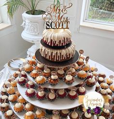 a wedding cake and cupcakes on a table