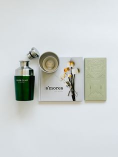 an assortment of perfumes and books on a white surface with the words s'mores written below them