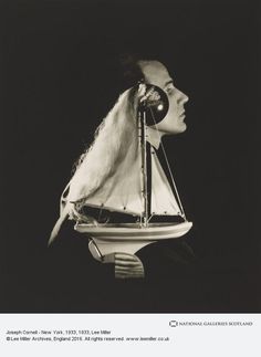 a black and white photo of a woman with a sailboat on her head