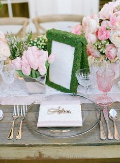 the table is set with pink flowers and silverware