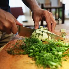 a man is cutting up some vegetables on a board