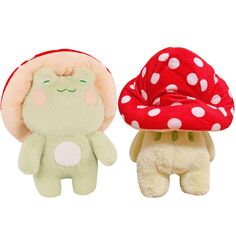 two stuffed animals sitting next to each other in front of a mushroom hat on top of one another