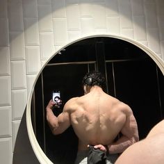 a man taking a selfie in front of a bathroom mirror with his cell phone