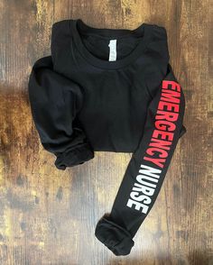 a black shirt that says emergency nurse on the front and back with red writing across the sleeves