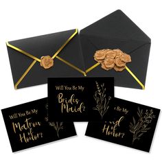 three black envelopes with gold foil lettering on them and some cookies in the middle