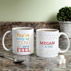 two coffee mugs with the words you're only as young as you feel