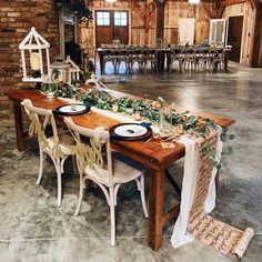 a long table with plates and place settings is set up in the middle of a large room