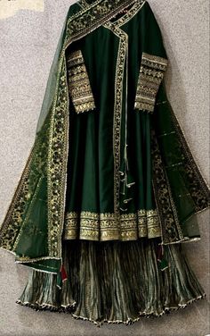 a green and gold wedding outfit hanging on the wall