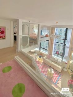 a living room filled with furniture next to a large window covered in pink and green rugs